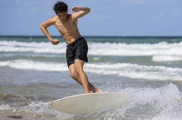 Gabriel Titensky, 18, a student from University of South Florida, rides a skimboard at Las Olas Beach during spring break on Friday, March 20, 2026, in Fort Lauderdale, Fla.