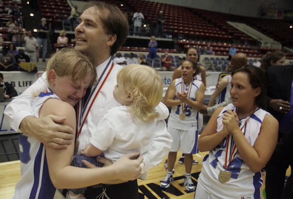 Barron Collier head coach Mike Hamburg holds his daughter, Jordan, then 19 months, as he hugs point guard Dani Johnson after topping Winter Haven in the 2008 state championship game.