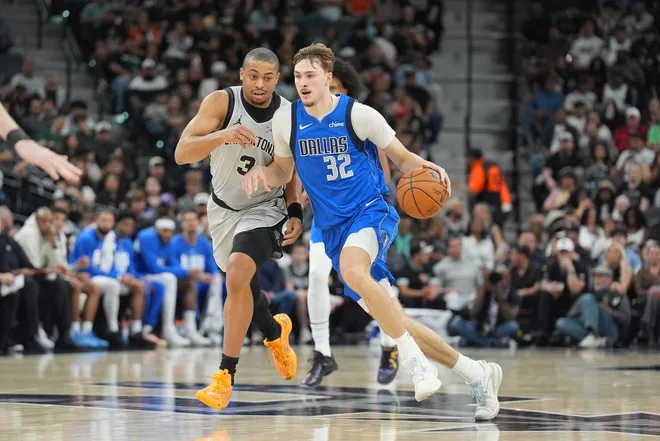 Feb 7, 2026; San Antonio, Texas, USA; Dallas Mavericks forward Cooper Flagg (32) dribbles against San Antonio Spurs forward Keldon Johnson (3) in the second half at Frost Bank Center.