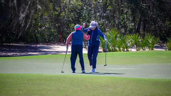 Ann Probert and Barbara Young celebrate on the green at the 2018 Citrus Bowl.