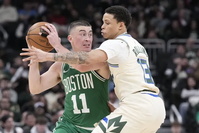 Mar 2, 2026; Milwaukee, Wisconsin, USA; Boston Celtics guard Payton Pritchard (11) drives against Milwaukee Bucks guard Ryan Rollins (13) in the second half at Fiserv Forum.