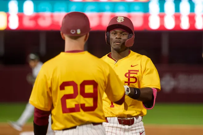 Chase Williams hands his gear off after a walk as FSU baseball wore their throwback “mustard” jerseys as the Seminoles hosted Jacksonville on Tuesday, March. 3, 2026 at Dick Howser Stadium