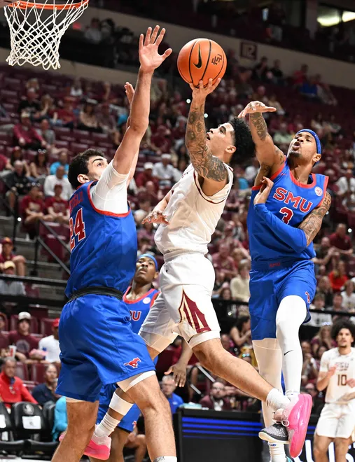 Mar 7, 2026; Tallahassee, Florida, USA; Florida State Seminoles guard Kobe MaGee (5) goes up for a shot against Southern Methodist Mustangs center Samet Yiğitoğlu (24) and forward Corey Washington (3) during the first half at Donald L. Tucker Center. Mandatory Credit: Melina Myers-Imagn Images