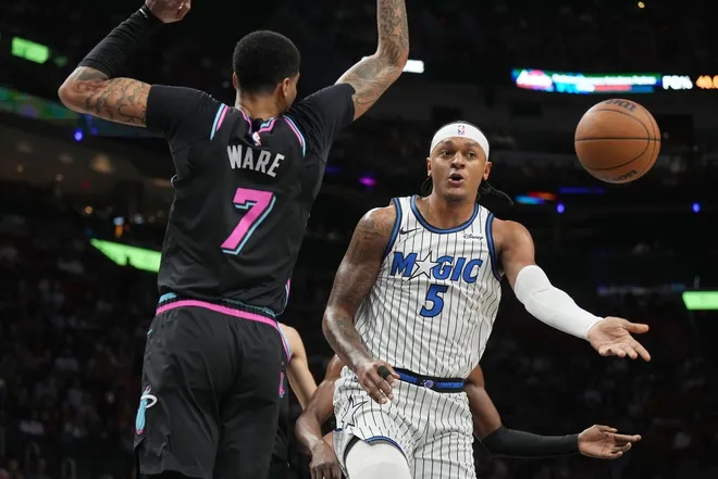 Mar 14, 2026; Miami, Florida, USA; Orlando Magic forward Paolo Banchero (5) passes the ball as he drives to the basket as Miami Heat center Kel'el Ware (7) defends during the first half at Kaseya Center.
