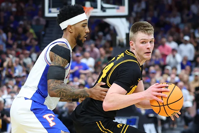 TAMPA, FLORIDA - MARCH 22: Bennett Stirtz #14 of the Iowa Hawkeyes dribbles the ball against Boogie Fland #0 of the Florida Gators during the first half in the second round of the 2026 NCAA Men's Basketball Tournament at Benchmark International Arena on March 22, 2026 in Tampa, Florida. (Photo by Mike Carlson/Getty Images)