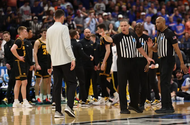 Mar 22, 2026; Tampa, FL, USA; Referees talk to Florida Gators head coach Todd Golden after a fight against the Iowa Hawkeyes in the first half during a second round game of the men's 2026 NCAA Tournament at Benchmark International Arena. Mandatory Credit: Matt Pendleton-Imagn Images