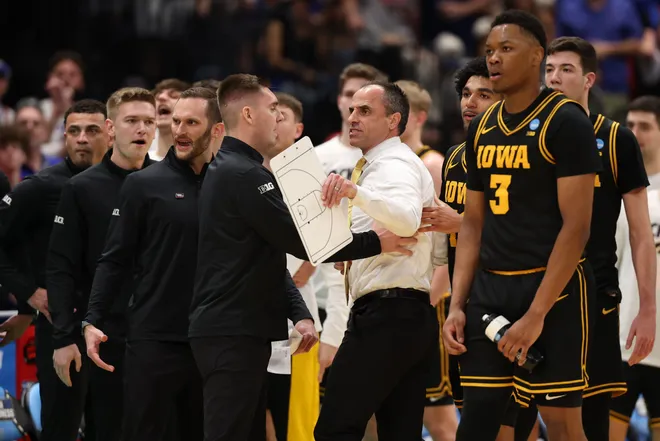 Mar 22, 2026; Tampa, FL, USA; Iowa Hawkeyes head coach Ben McCollum is held back after a fight against the Florida Gators in the first half during a second round game of the men's 2026 NCAA Tournament at Benchmark International Arena. Mandatory Credit: Matt Pendleton-Imagn Images