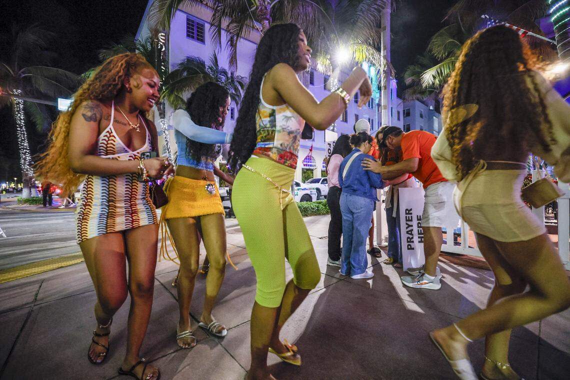 Women dance along Ocean Drive as a group prays with the God Squad, an interfaith prayer team of volunteers for the Miami Beach Police Department. They serve as goodwill ambassadors during spring break in South Beach, Friday, March 20, 2026.