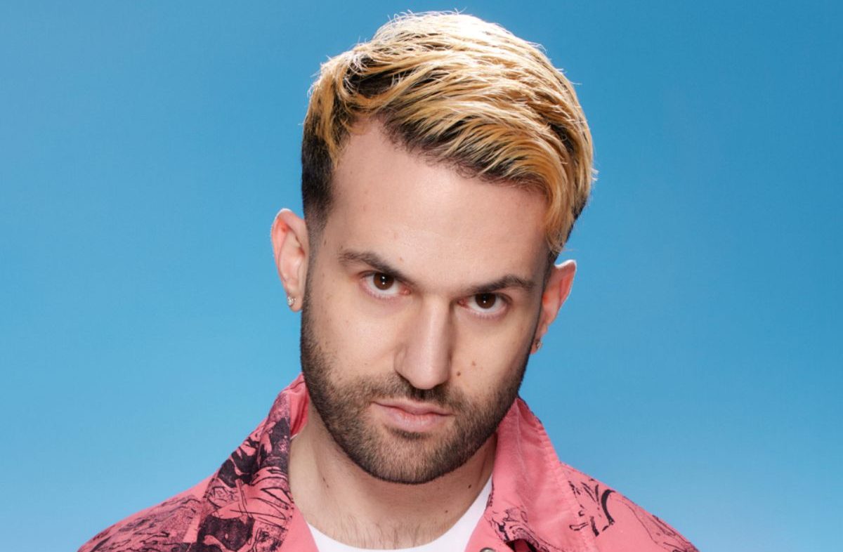 Photo of a man looking at the camera against a light blue background.