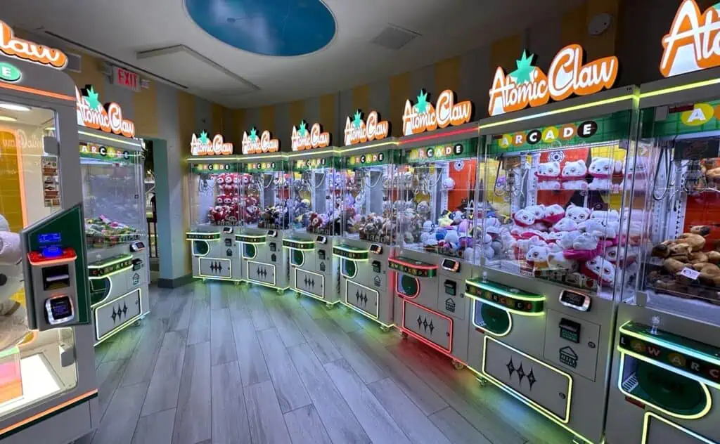 Inside a claw machine arcade. Purple lights are reflected on the hardwood floor