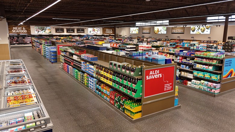 Interior of a newly remodeled ALDI supermarket featuring wide aisles, an ALDI Savers endcap, and grocery departments.