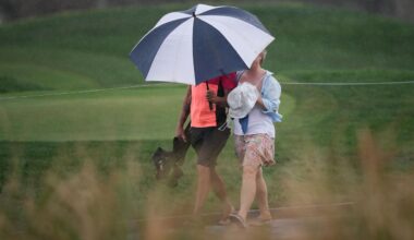 Fans walk in the rain along the fifth hole during the third round of the Arnold Palmer Invitational at Bay Hill golf tournament Saturday, March 7, 2026, in Orlando, Fla. (AP Photo/Matt Slocum)