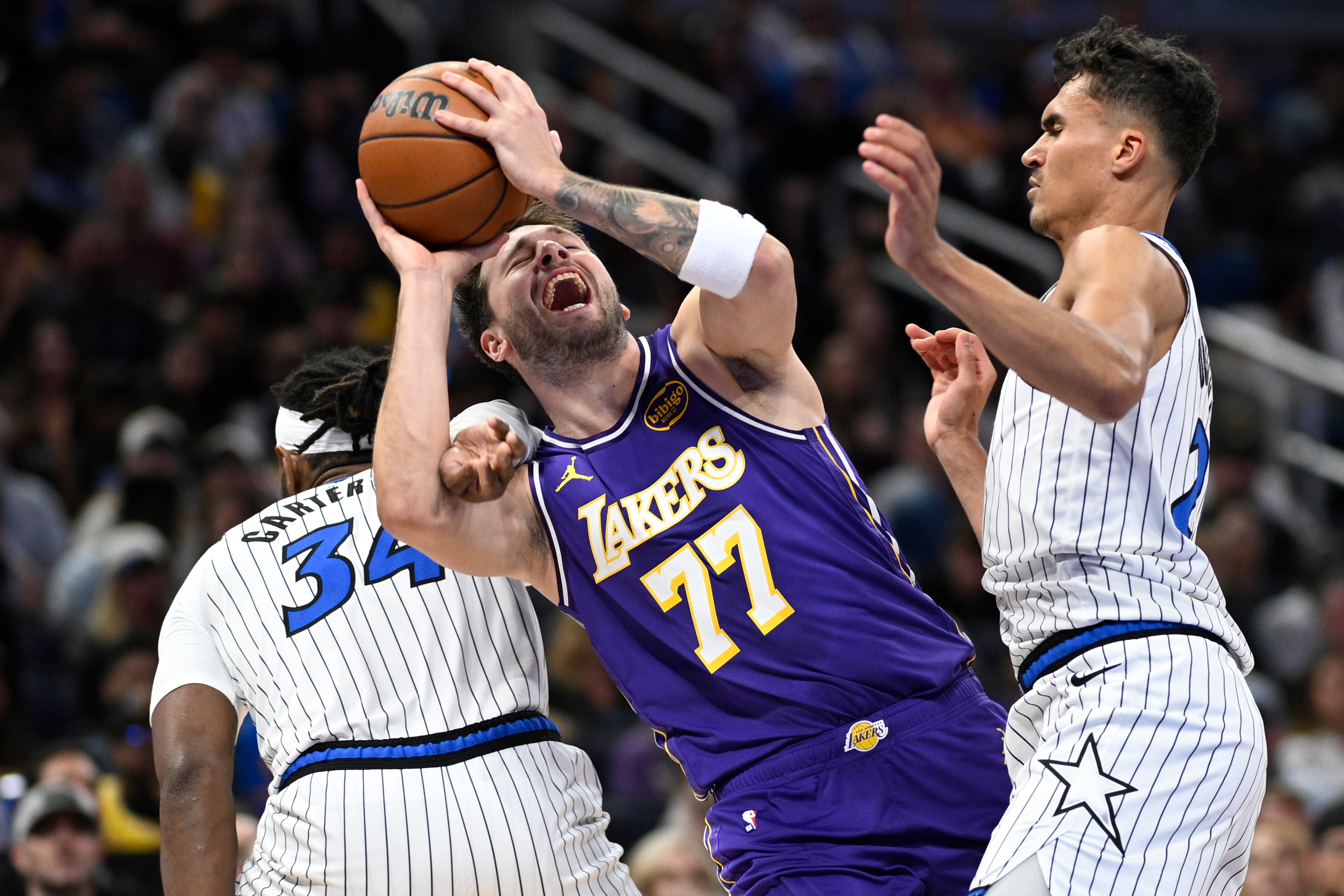 Lakers guard Luka Doncic (77) is fouled by Orlando Magic...