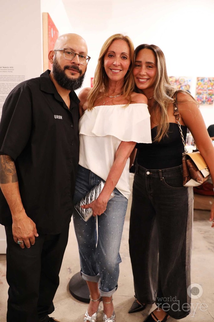 photo of two women and a man posing together for a photo