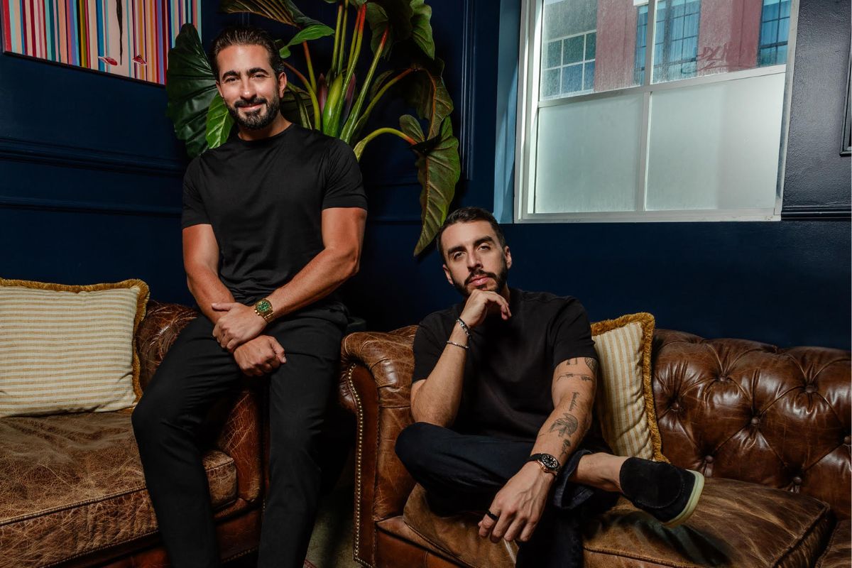photo of two men sitting on a leather couch