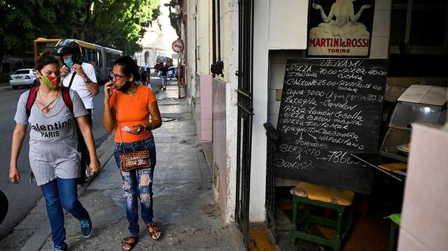 In this file photo, women walk past a private café in Havana, Cuba, on Oct. 6, 2021. In this file photo, women walk past a private café in Havana, Cuba, on Oct. 6, 2021.