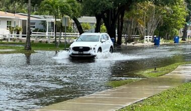 A vehicle drives down a flooded road in the Shore Acres neighborhood in St. Petersburg in April 2024 (photo: Josh Rojas).