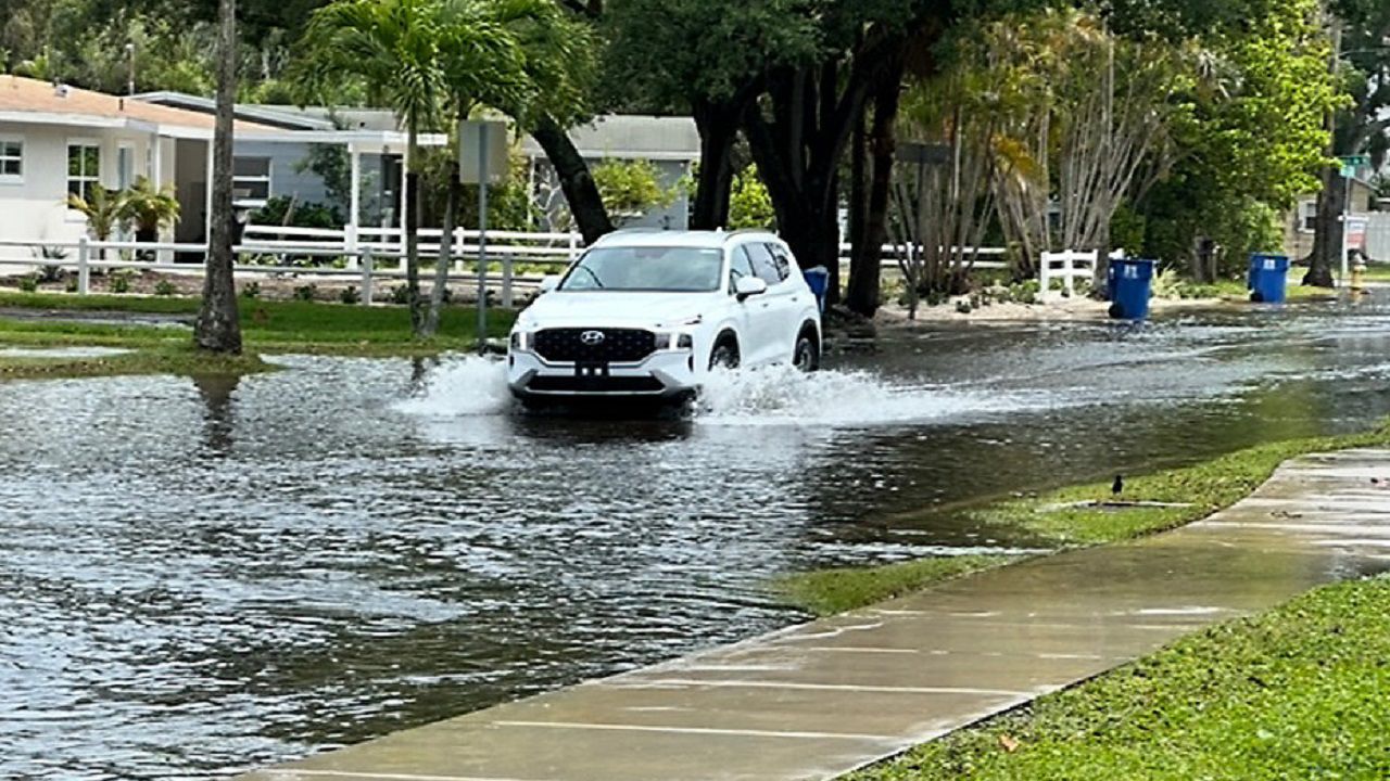 A vehicle drives down a flooded road in the Shore Acres neighborhood in St. Petersburg in April 2024 (photo: Josh Rojas).