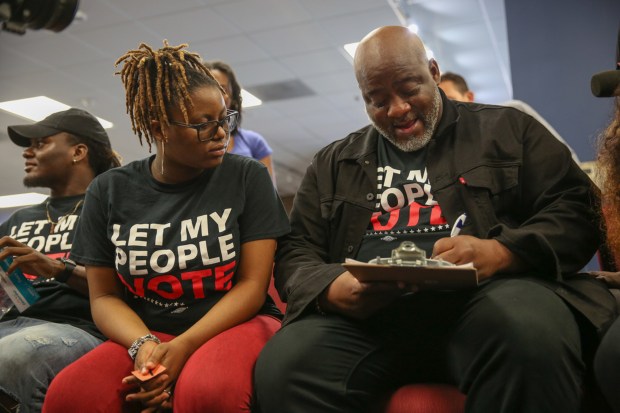 Desmond Meade, alongside his daughter Xcellence, registers to vote under Amendment 4 as a returning citizen, Tuesday, January 08, 2018. Meade leads the Florida Rights Restoration Coalition.