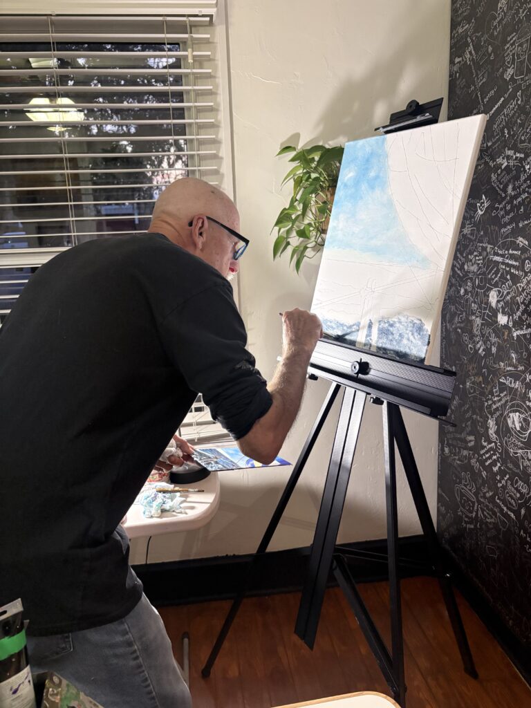 Bradley Craven paints a scene by the seaside during the party.