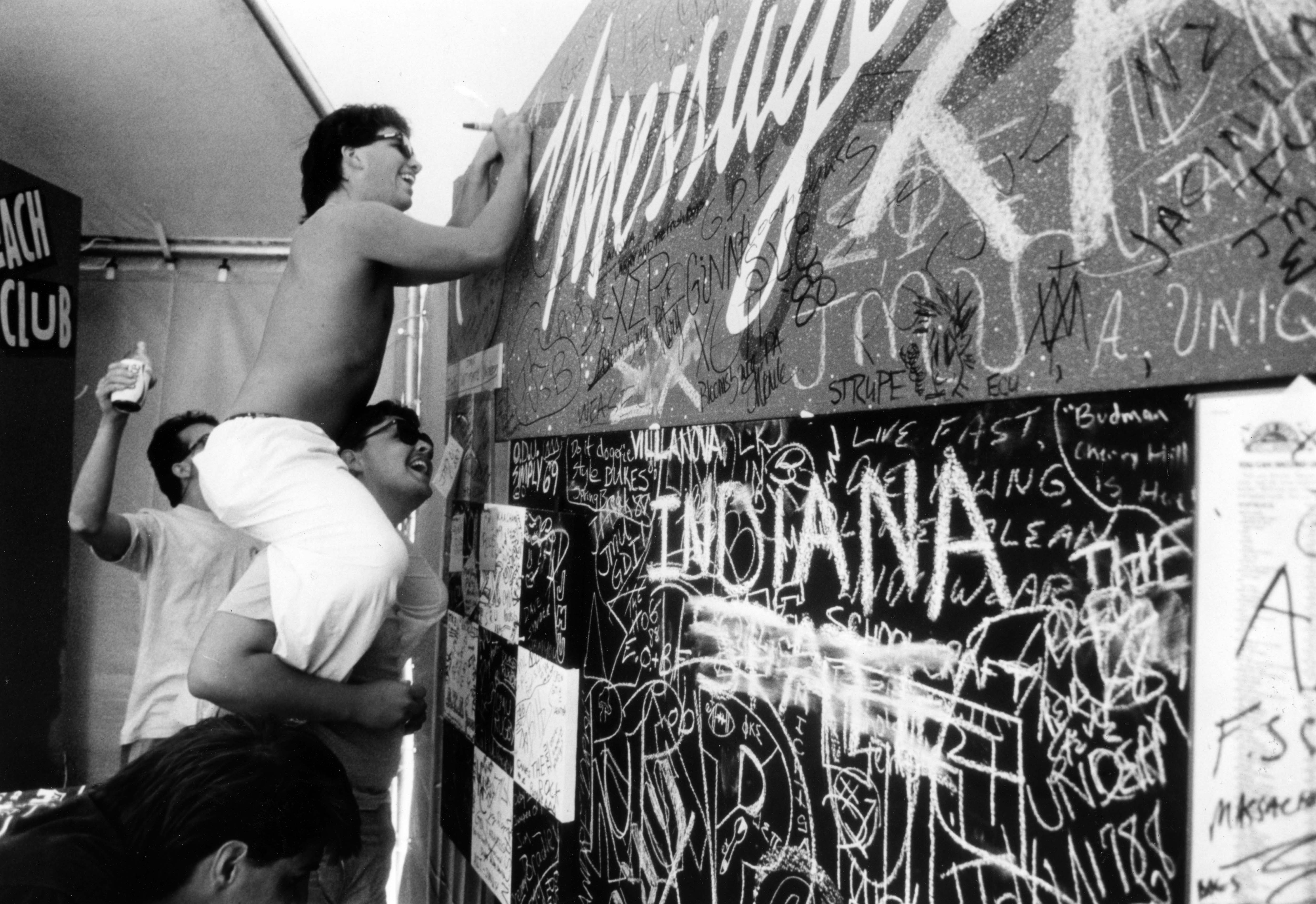Marty Spiegel (on shoulders) and classmate, Rob Howell, writes a...