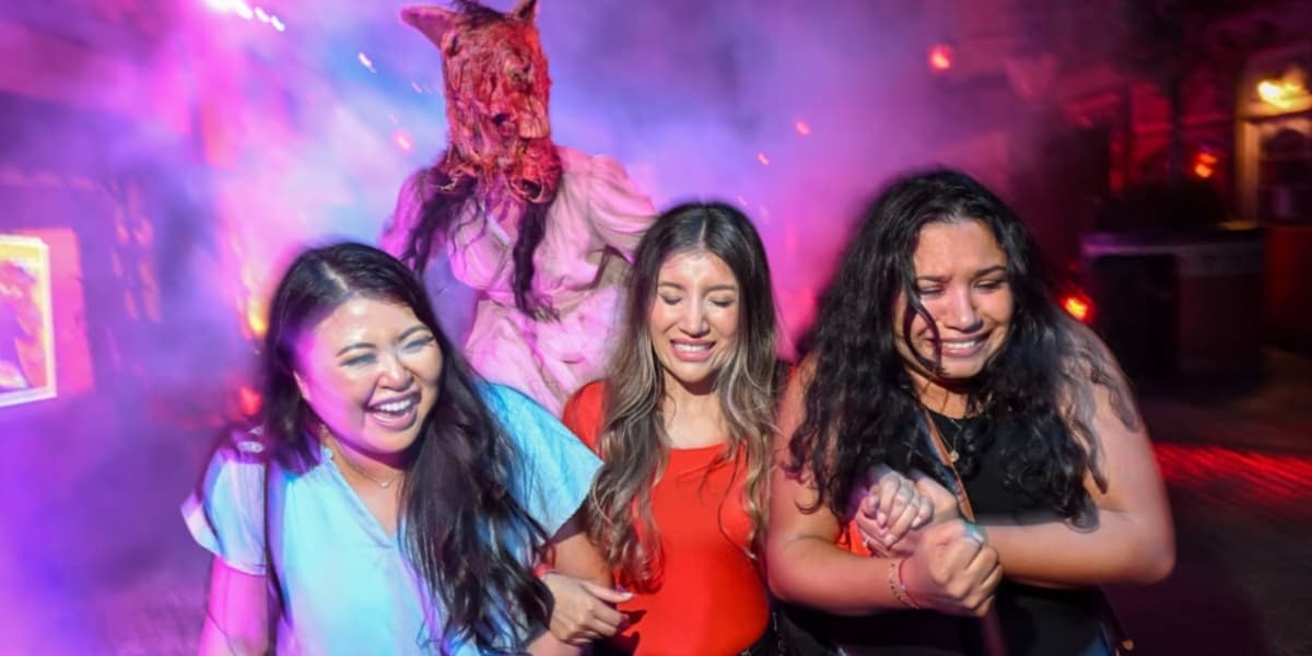 Three guests running away from a skinless horse demon at Halloween Horror Nights in Universal Studios Hollywood