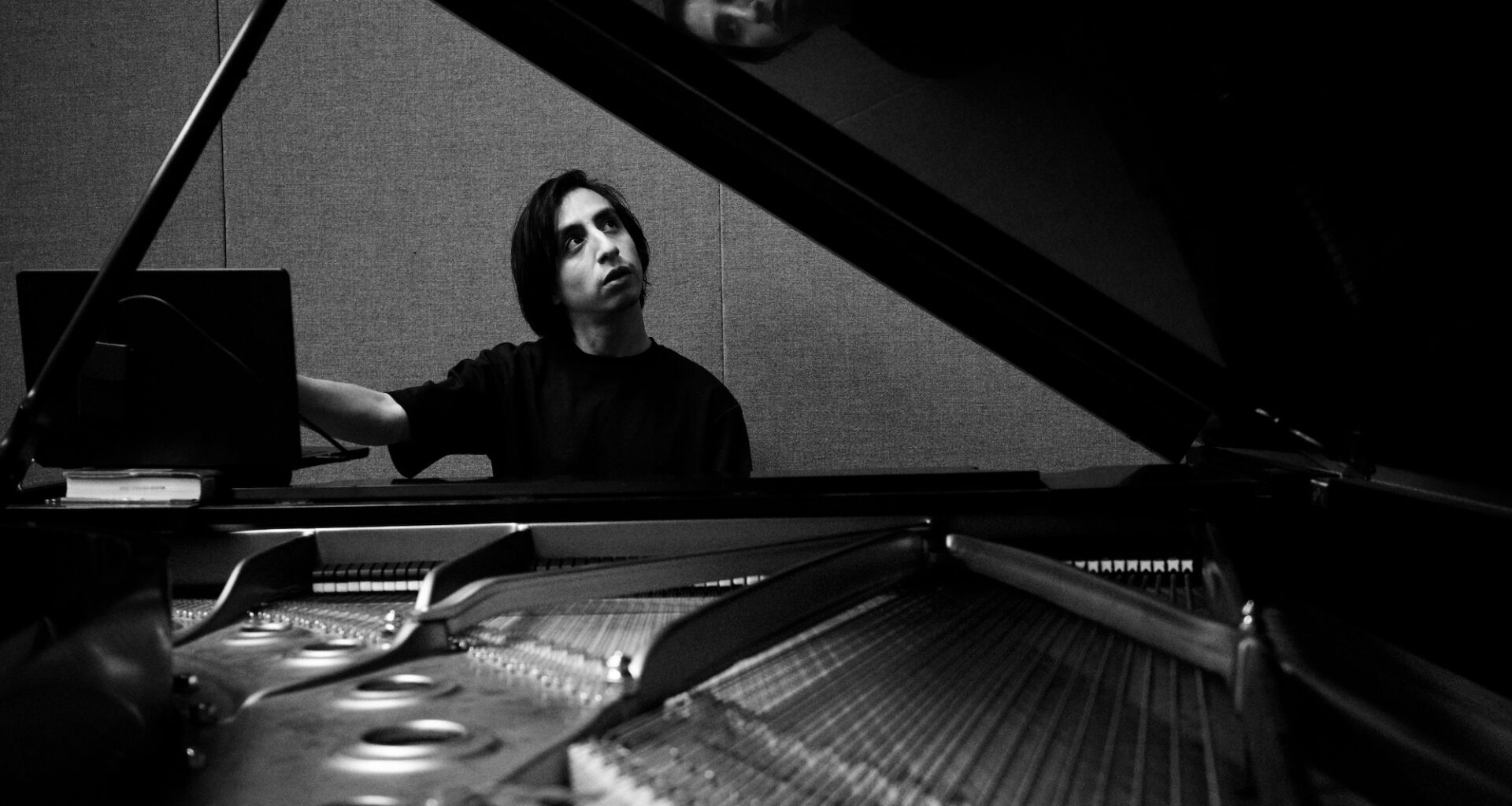 Photo of a man sitting by a piano