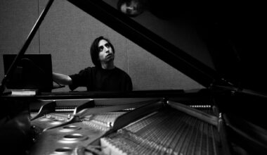 Photo of a man sitting by a piano