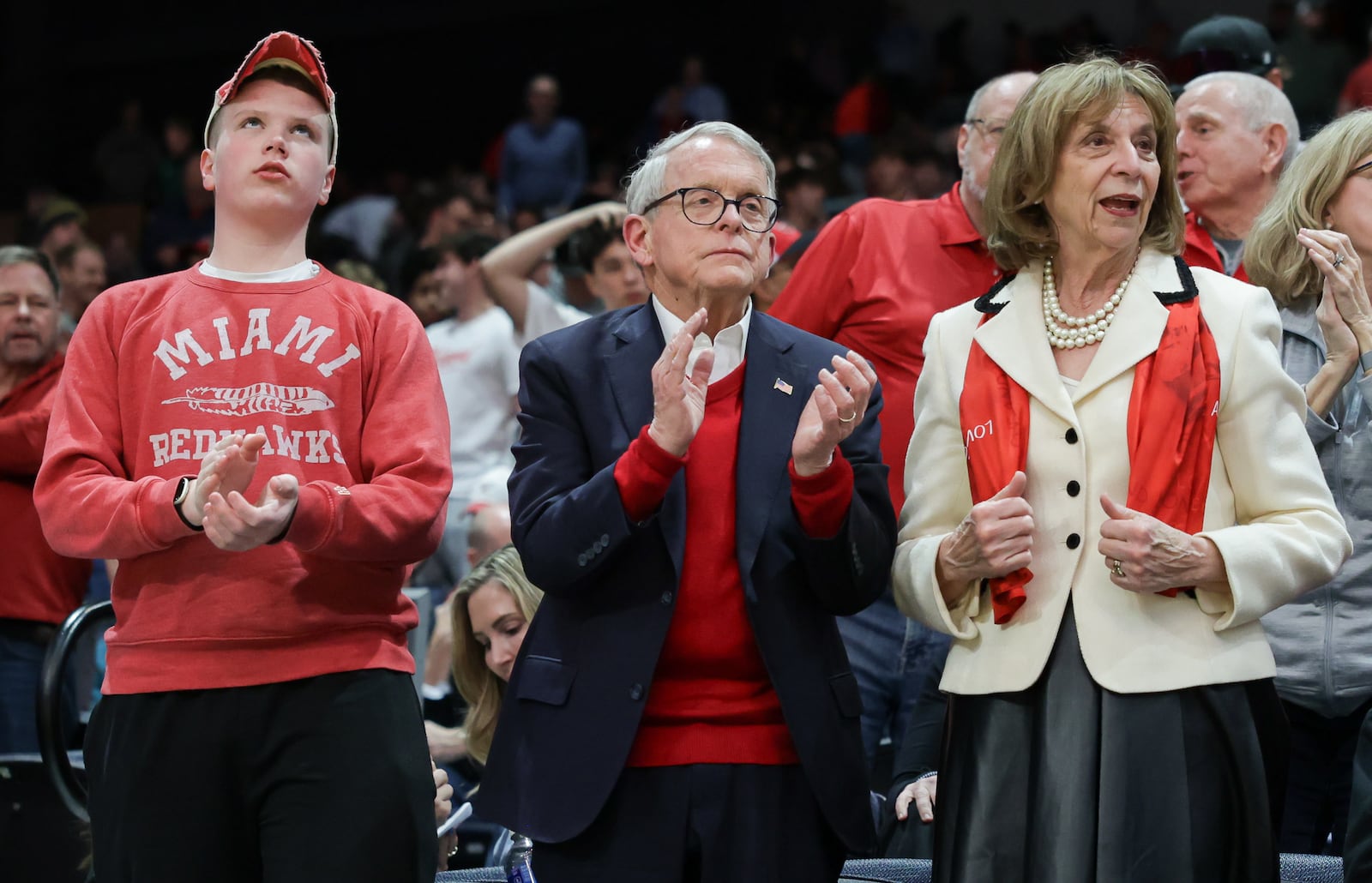 Gov. Mike DeWine (Middle) and First Lady Fran DeWine (right) cheer as Miami University players run onto the floor for pregame warmups before an NCAA First Four game against Southern Methodist University on Wednesday, March 18 at University of Dayton Arena. BRYANT BILLING / STAFF