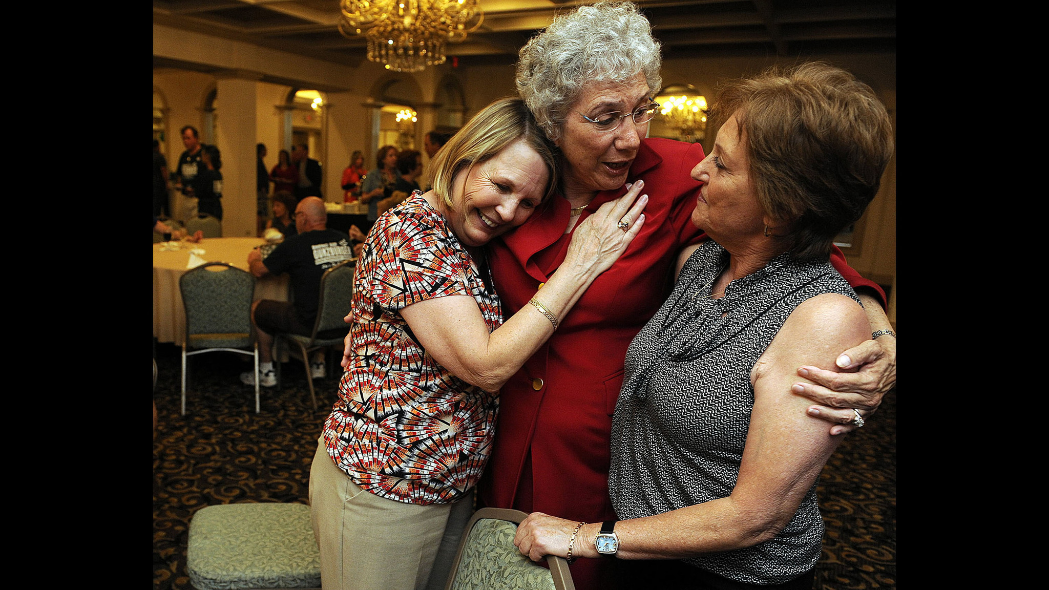 Sue Gunzburger, right, receives a hug from county commission aids,...