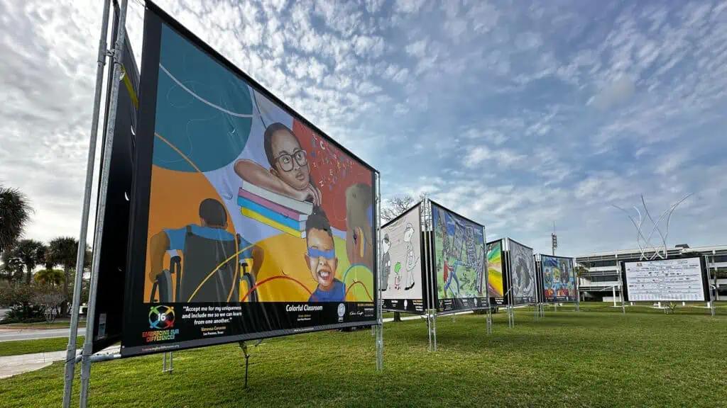 multiple artist banners set up along a walkway at a waterfront park