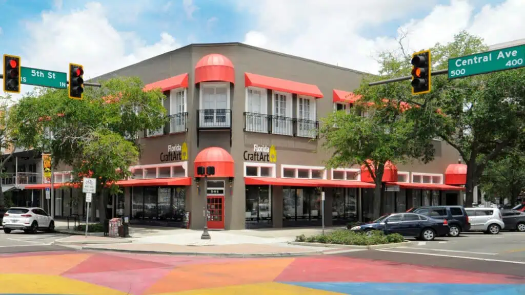 Exterior of a two-story building with beige walls and red awnings located at the corner of 5th Street and Central Avenue.