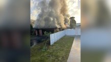 The flames consumed a house on 1400 River Island Road, authorities said. A photo of the scene shows the roof of the structure covered in plumes of smoke as flames burn. 
