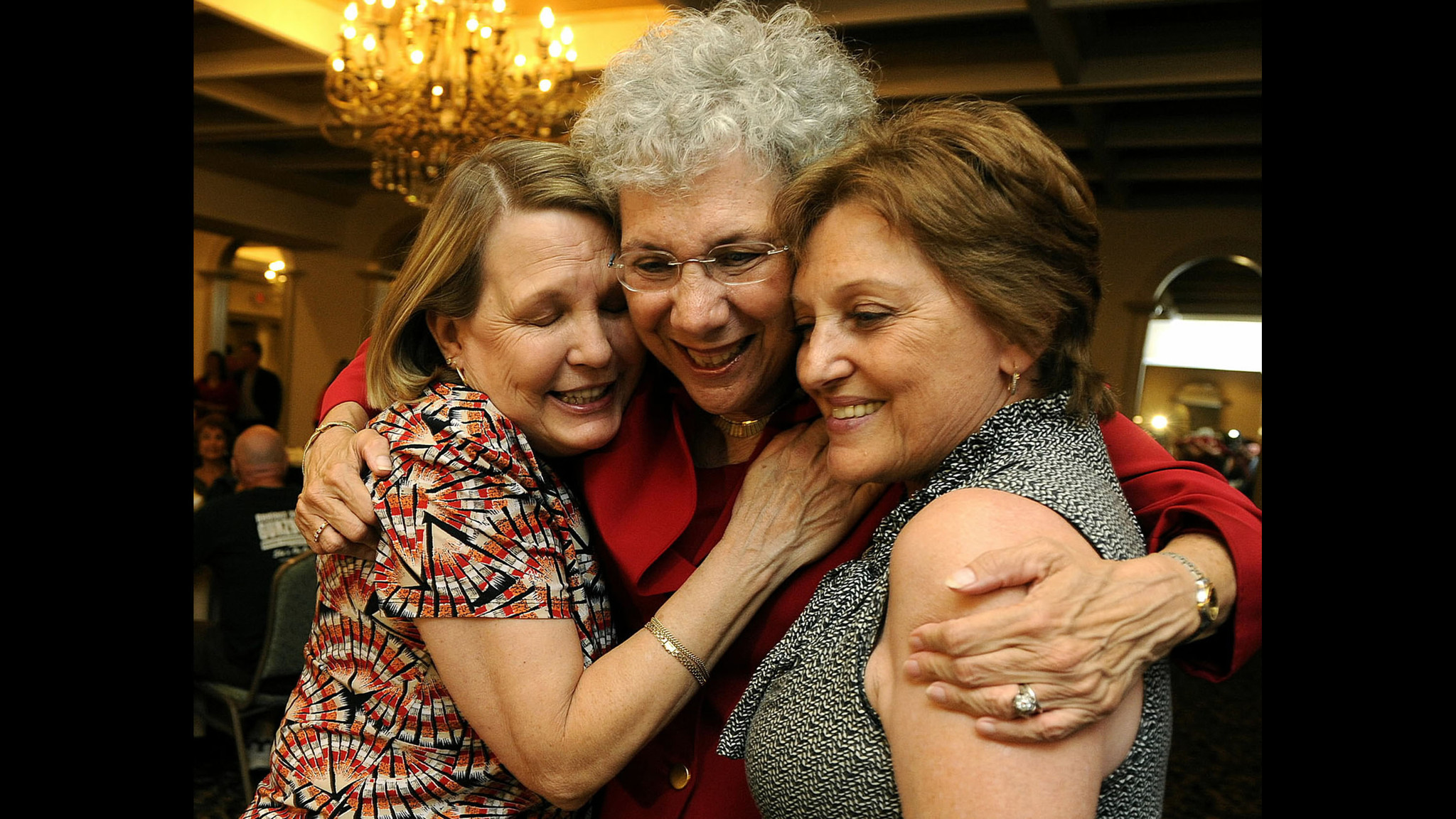 Sue Gunzburger, right, receives a hug from county commission aids,...