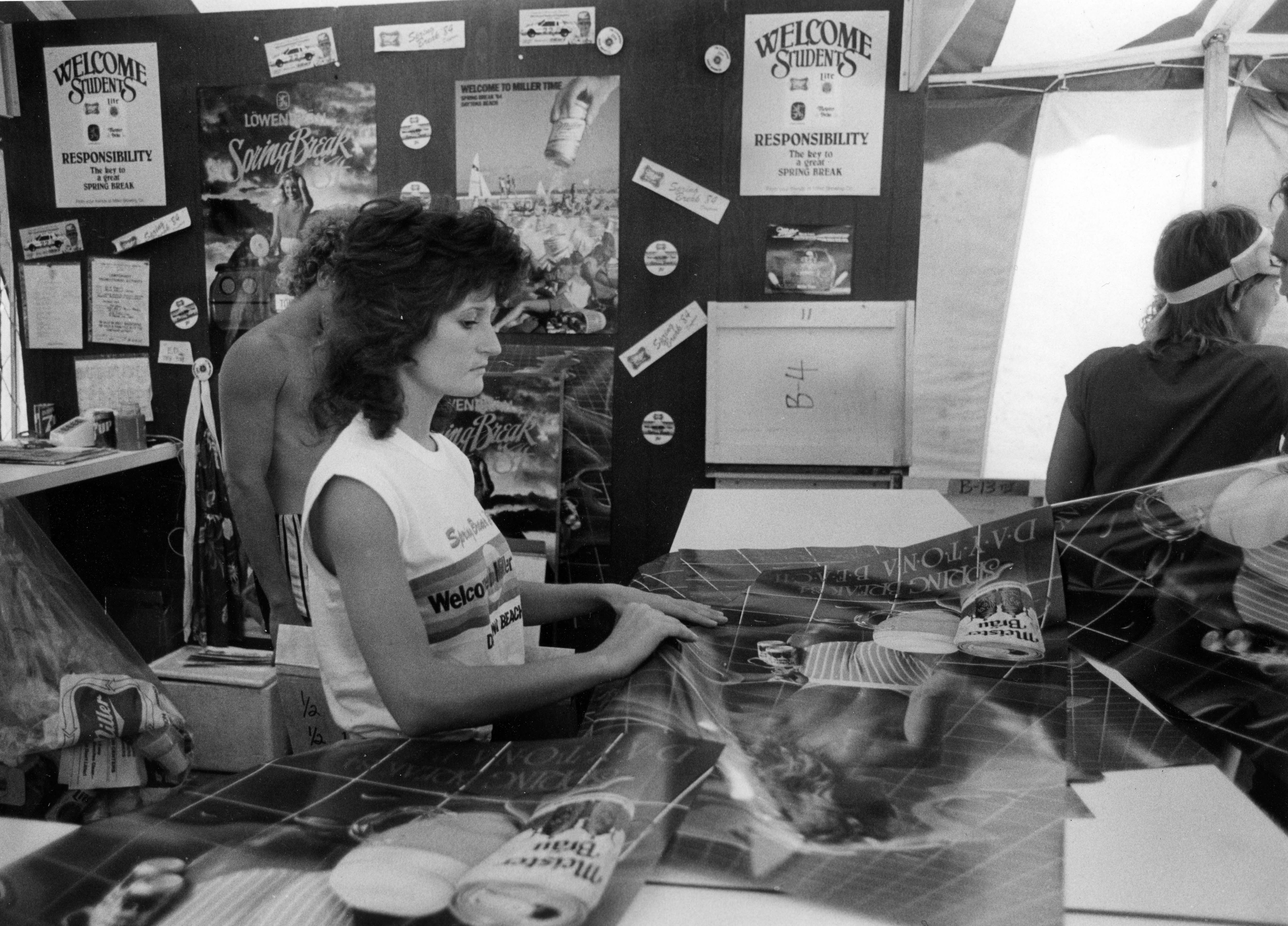 Julie Ashby of Daytona Beach gives away posters at the...