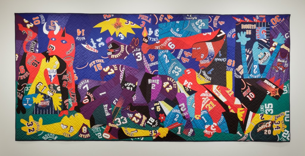 photo of a quilt using sports jerseys to depict abstract figures including bulls and people in the stole of Picasso's Guernica
