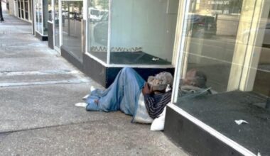 Two homeless men sleep in a doorway on Monroe Street.