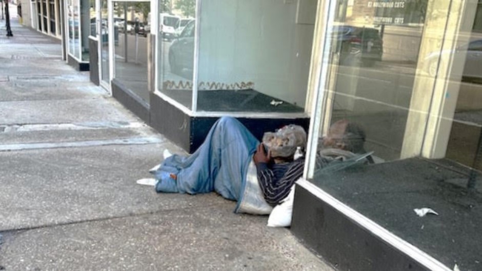 Two homeless men sleep in a doorway on Monroe Street.