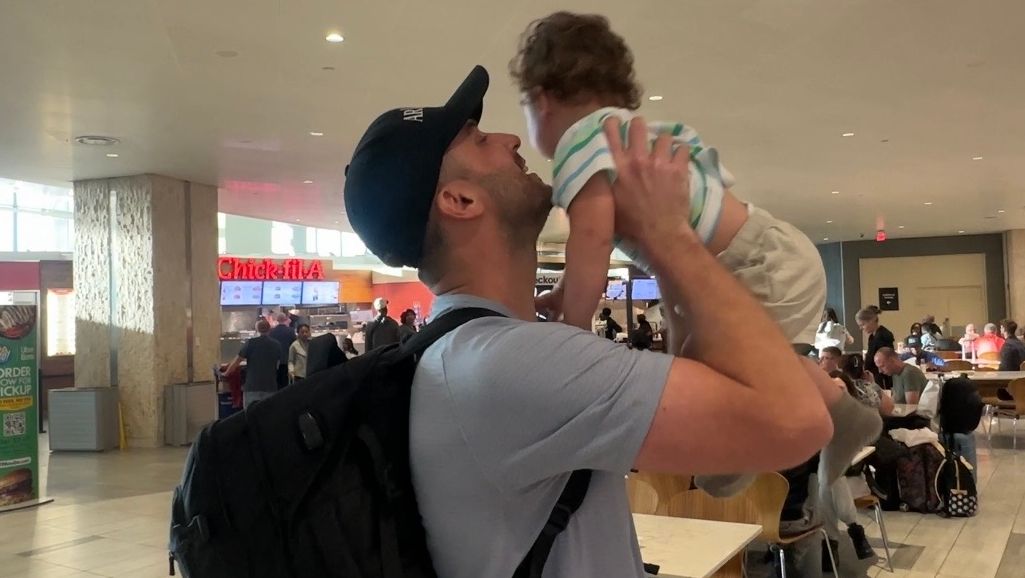 Cody Greene reunites with his son at Tampa International Airport Thursday after being stuck overseas because of the war with Iran. (Spectrum News/Lizbeth Gutierrez)