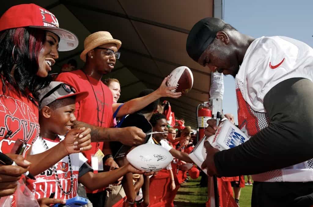 Football player signing autographs