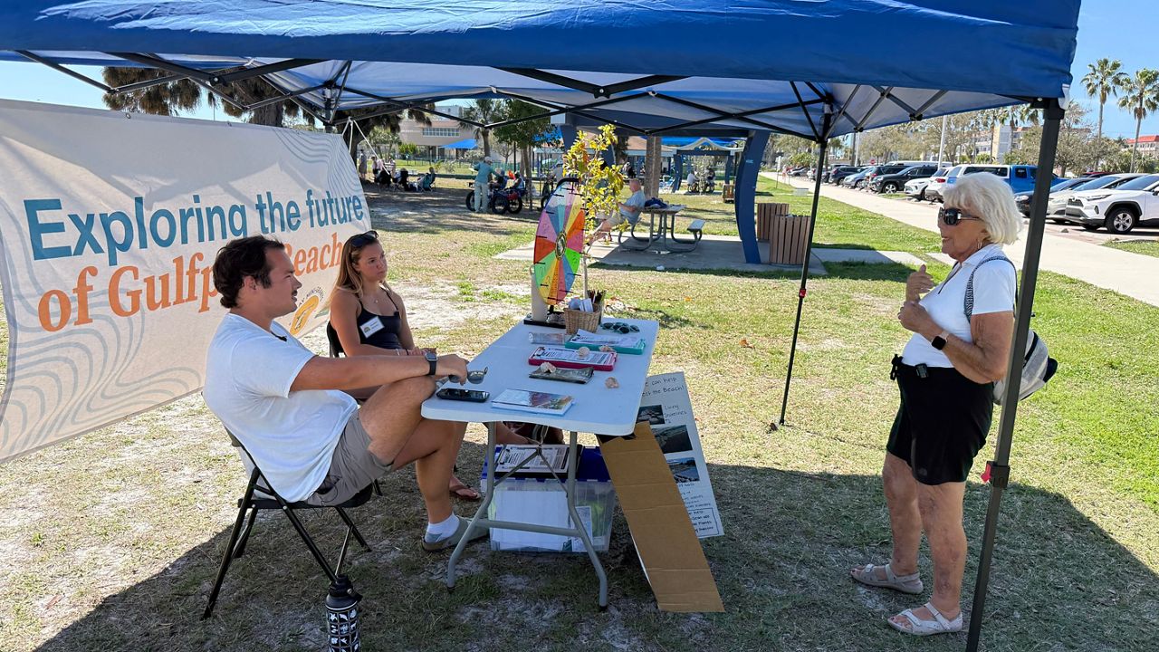 Student interns John Carreiro and Summer Sorensen, who are part of Eckerd College's Gulf Scholars program, speak with a resident as part of a push to get input to see what kind of beach resilience projects the public supports. (Spectrum News/Tyler O'Neill)