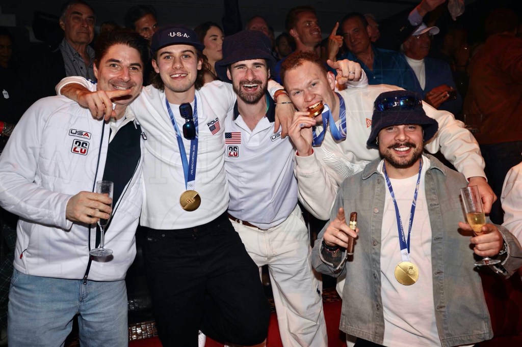 photo of Olympians huddling together wearing their medals