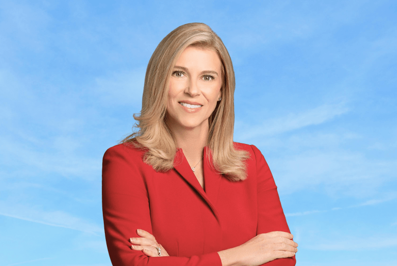 Leela Gray, retired U.S. Army Brigadier General and 2026 Democratic candidate for Florida’s 13th Congressional District, posing for a portrait in a red blazer against a blue sky background.