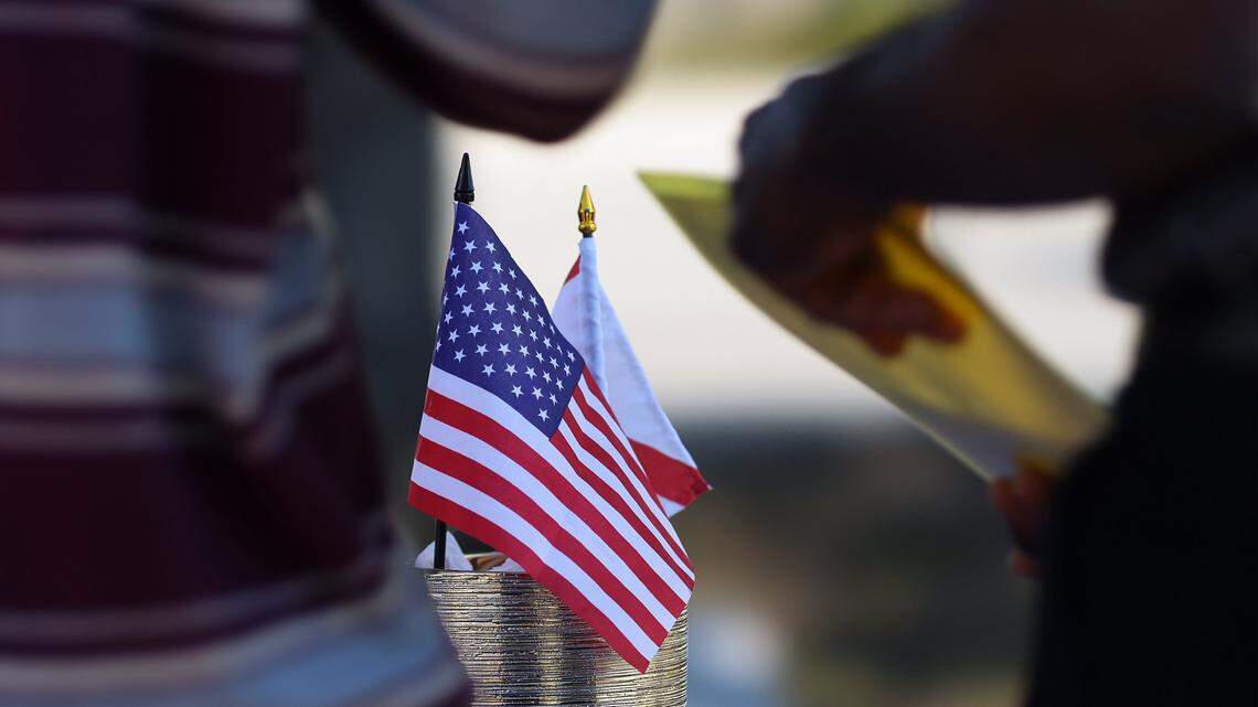 The American and State flags are on display as TPS recipients inquire about the process of licensing renewal during a driver's license renewal event for Haiti's TPS recipients was held at Carver Ranches Library in West Park, Florida, on February 26, 2026, to help Haitian immigrants and others update their licenses.