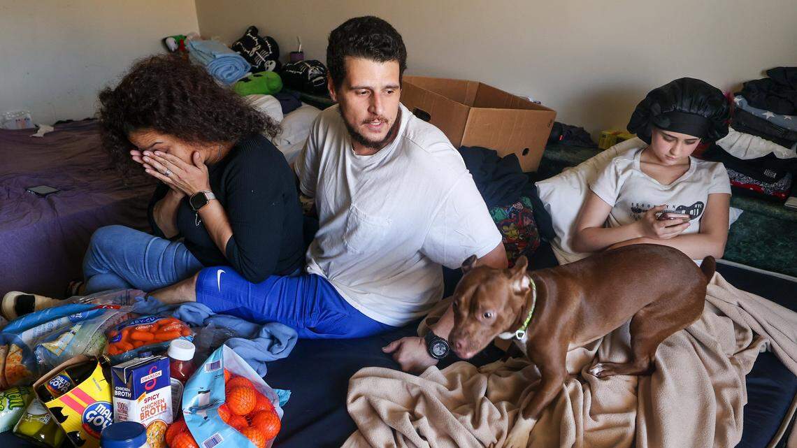 Michael Torres, center, and wife Diana Olivo, left, Maylynda, right, and her two brothers, not pictured, have been sharing a motel room for the last six months with their pets. He does not know how long they'll be able to afford to stay there, and he reflects on the challenges of being unsheltered on Wednesday, February 25, 2026, in Miami-Dade, Florida.