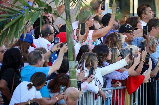 A small group of invitees takes cellphone pictures and video of President Donald Trump as upon his arrival during a visit to El Arepazo, a Venezuelan community hub in Doral, for a brief four-minute stop, greeting Republican guests invited to the restaurant on Monday, March 9, 2026, in Doral, Florida.