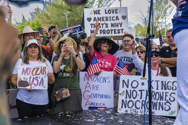 People hold signs at Tropical Park.