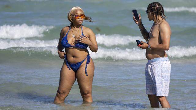 Gianni Montgomery takes a photo of Royale Elliott as they visit South Beach during spring break on Saturday, March 21, 2026, in Miami Beach, Fla.