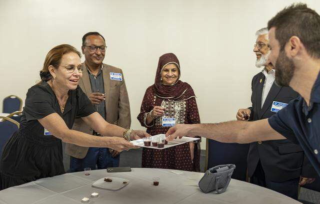 Mytyl Simancas shares grape juice with other guests attending an iftar dinner welcoming Muslims and Jews to discuss the role of fasting in both traditions at Temple Israel of Greater Miami on Friday, Feb. 27, 2026, in Miami, Fla.