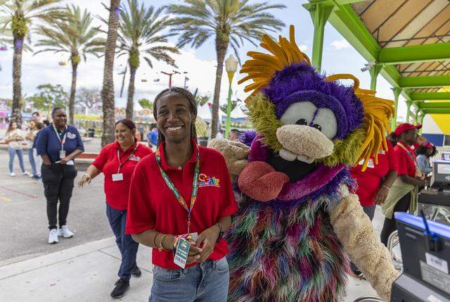 Janielia Nembhard, an event staff member, reacts as she and a member of The Fritters mascots wait for doors to open during the first day of the 74th annual Miami-Dade County Youth Fair on Thursday, March 12, 2026, in Miami, Fla.